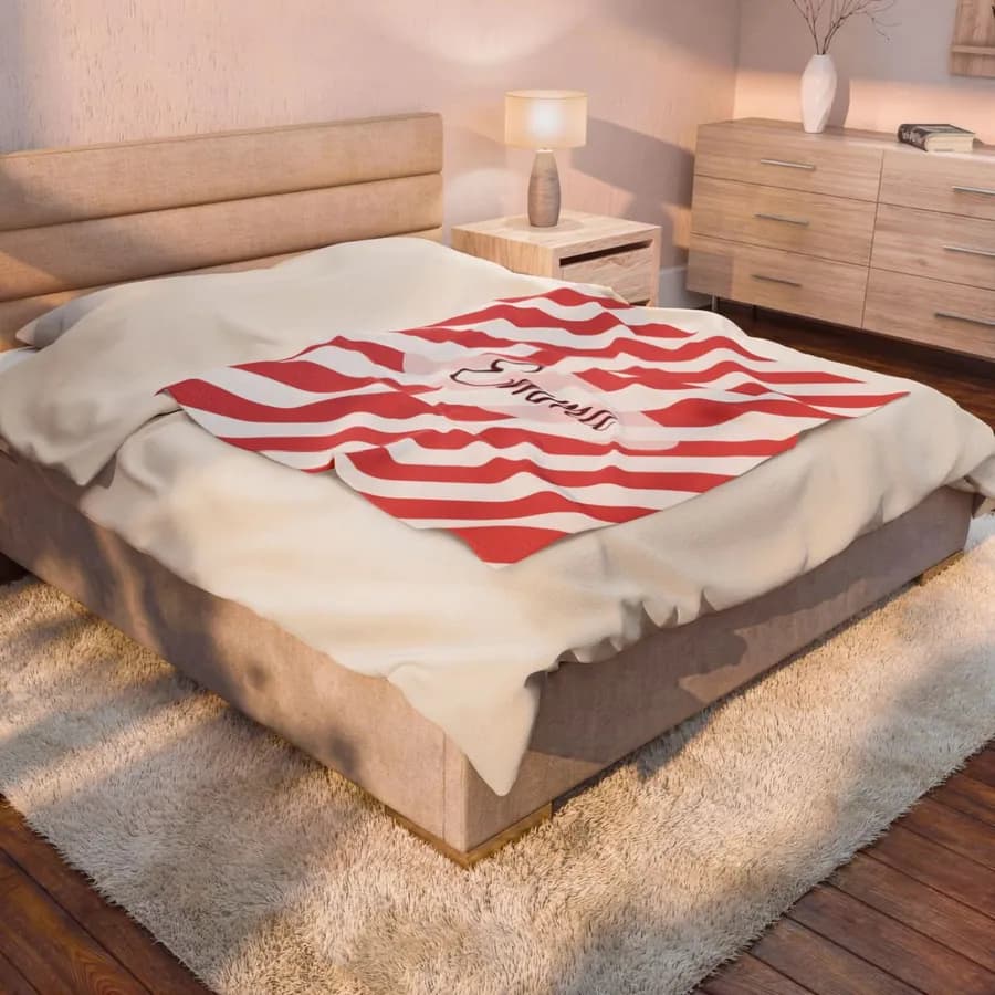 Example: throw blanket with the name Emma on a candy cane pattern on a bed